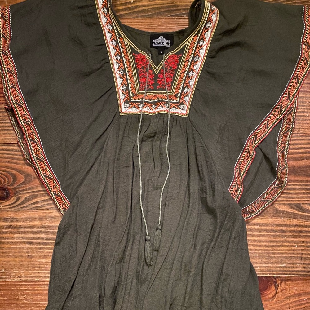 Olive top with detailed stitching around neck.